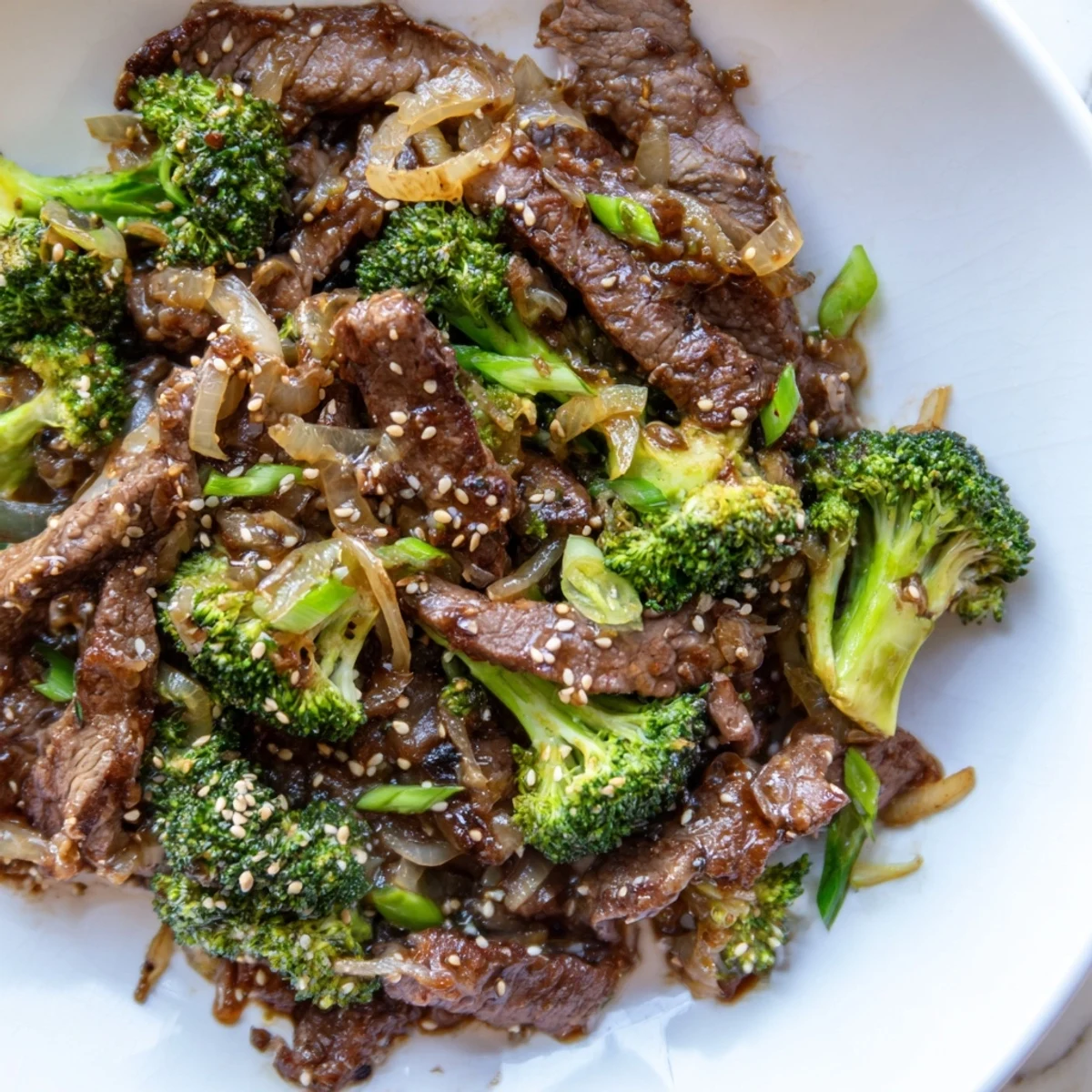 Close-up of a sizzling Beef and Broccoli Stir Fry with Garlic Sauce, featuring vibrant green florets and tender beef strips glistening with sauce.