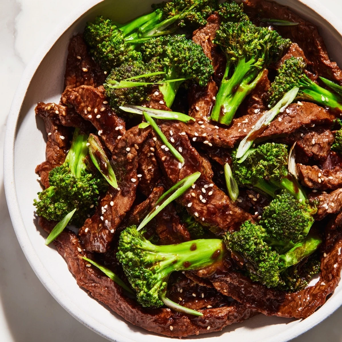 Freshly cooked Beef and Broccoli with Soy Sauce Glaze served in a white bowl, showcasing the glossy sauce coating the ingredients.