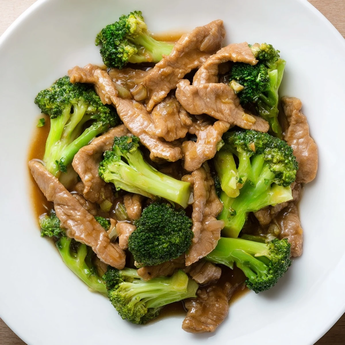 Sizzling wok presentation of Beef and Broccoli with Soy Sauce, showcasing freshly stir-fried broccoli and beef with a glossy soy glaze and fresh garlic garnish.
