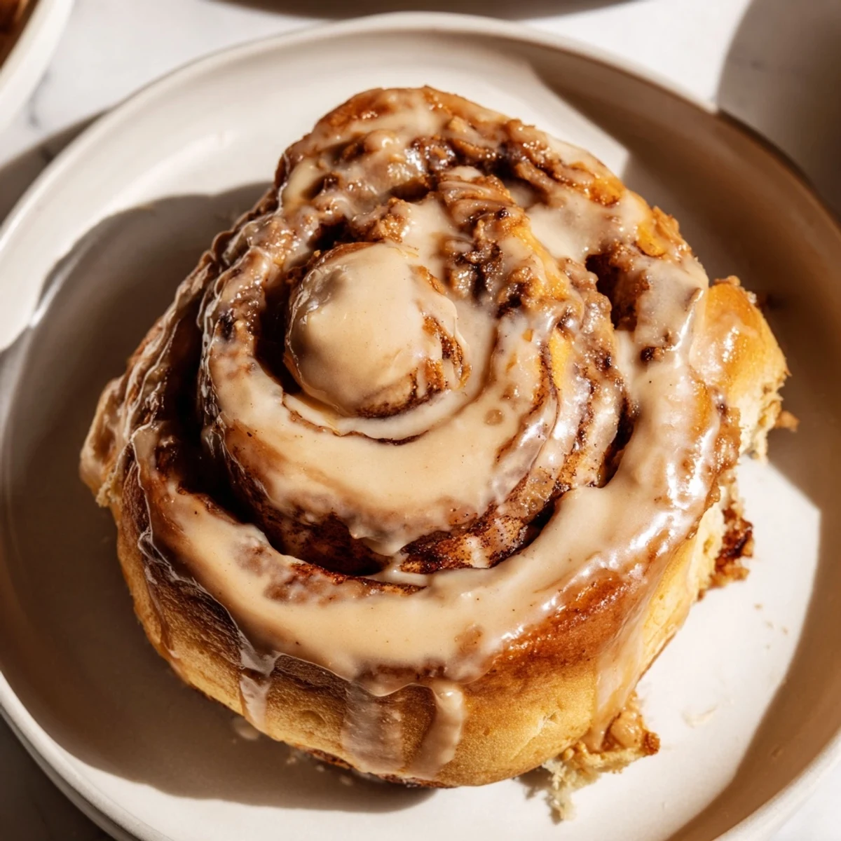 A close-up of Soft and Gooey Biscoff Cinnamon Rolls with melted cookie spread swirls and a sweet glaze, perfect for breakfast or dessert lovers.