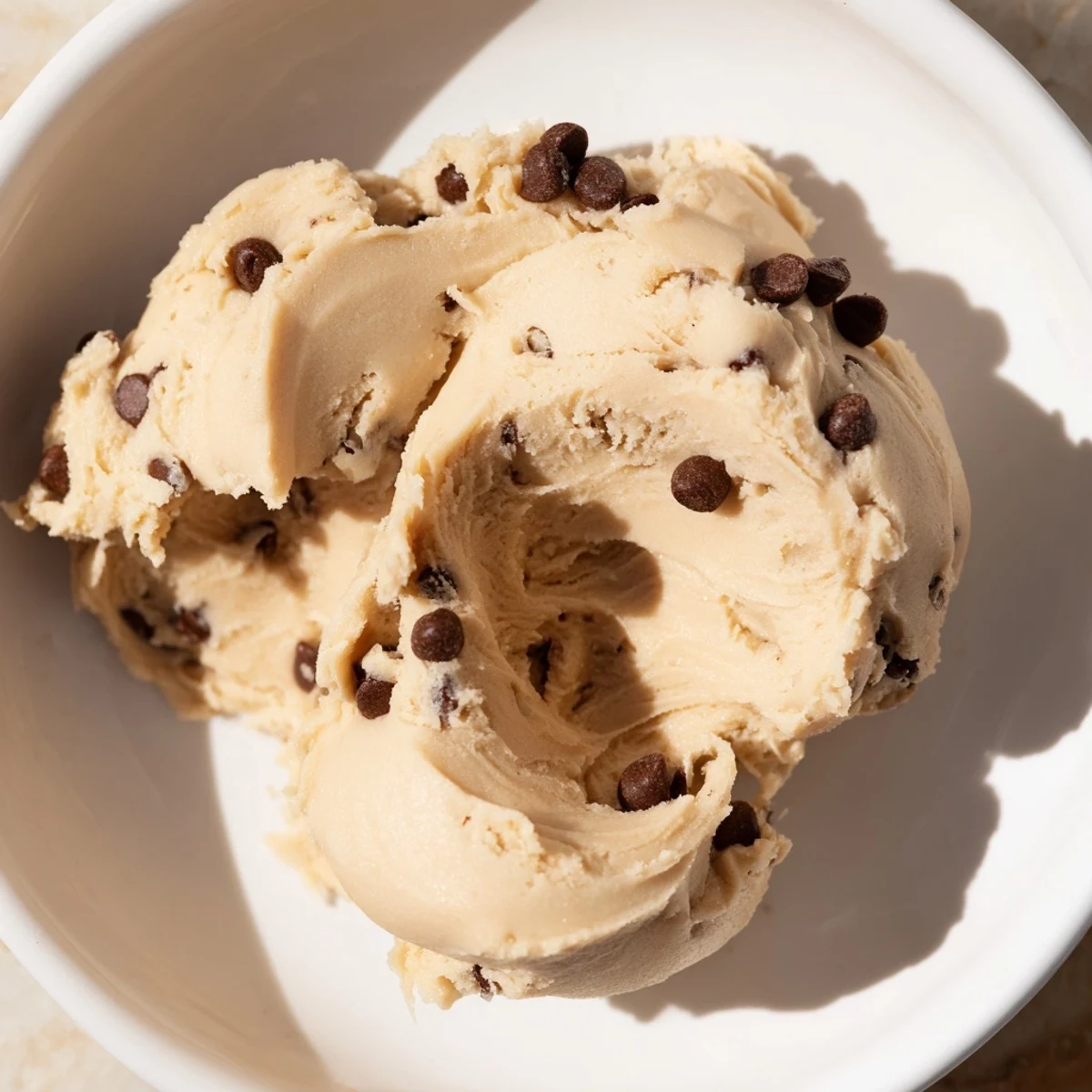 Chocolate Chip Greek Yogurt Cookie Dough served chilled in a jar with a drizzle of honey and nuts.