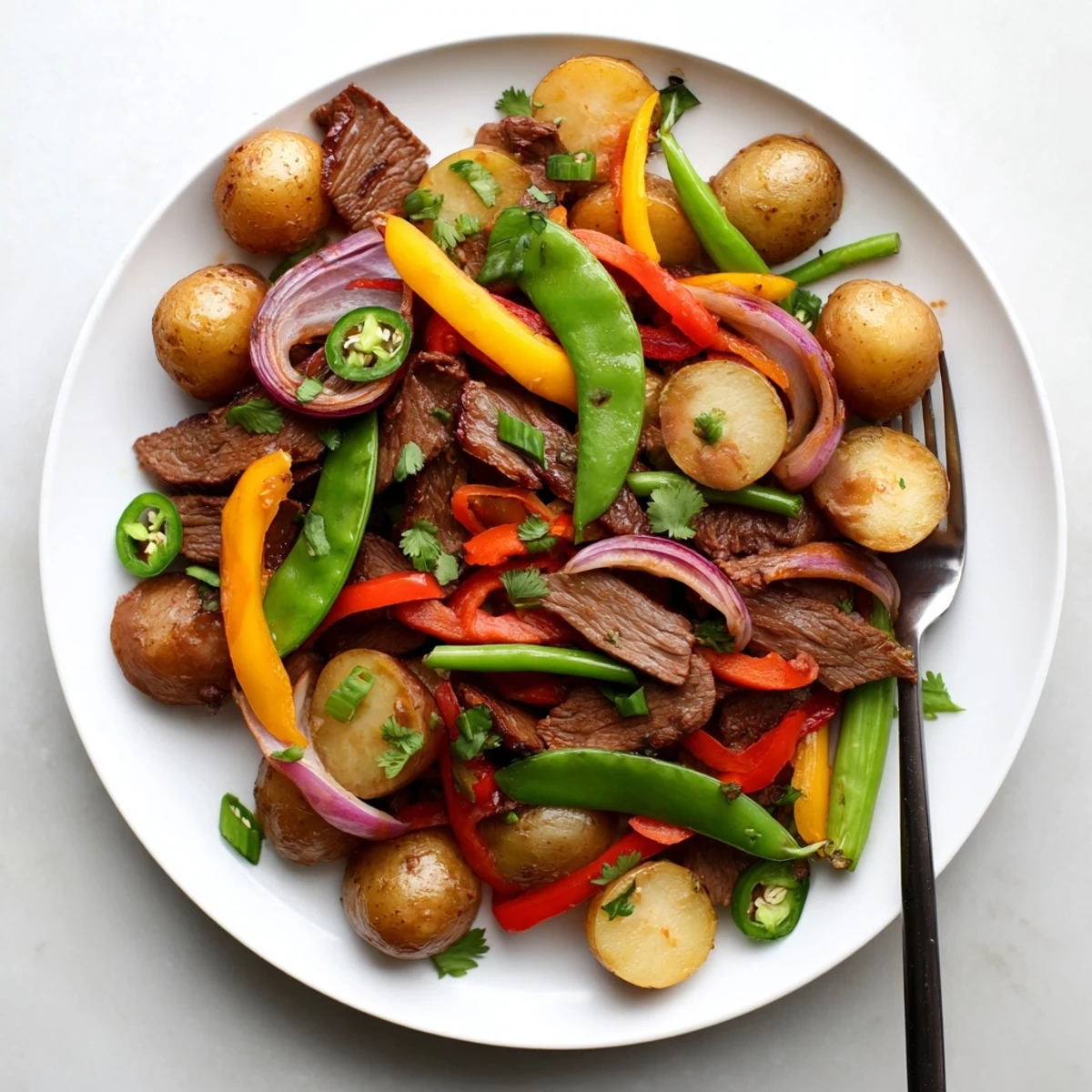 The Blackstone Cowboy Stir Fry Dinner is served in a skillet, garnished with fresh cilantro and scallions for a hearty meal.