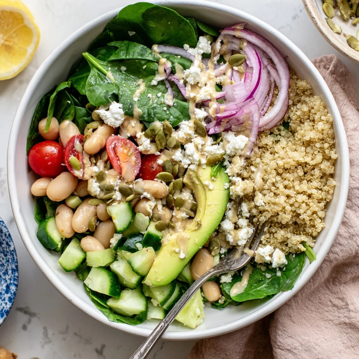 Fresh spinach and white beans glisten on a bed of fluffy quinoa in the Spinach & White Bean Ultimate Protein Power Bowl, drizzled with creamy lemon-tahini dressing.