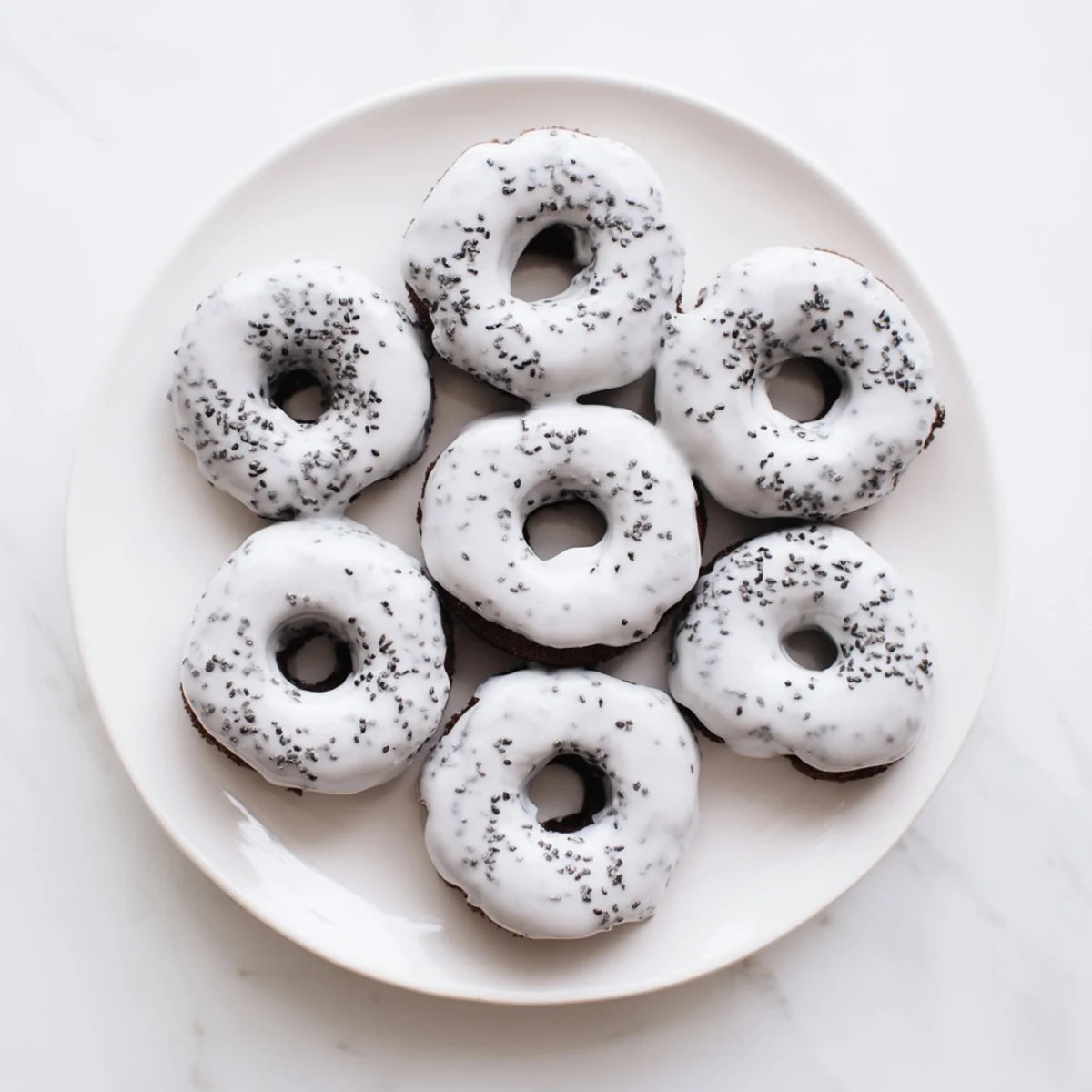 Gluten-free Black Sesame Mochi Donuts are displayed on a plate, offering a nutty aroma and a delicate, tender bite.