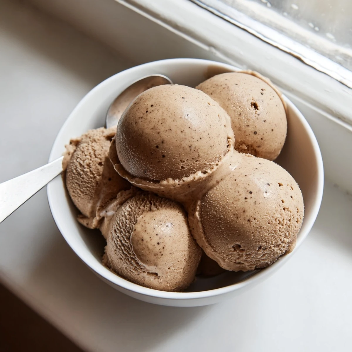 It's topped with crushed ice and a tiny spoon, ready for a delicious dessert serving.