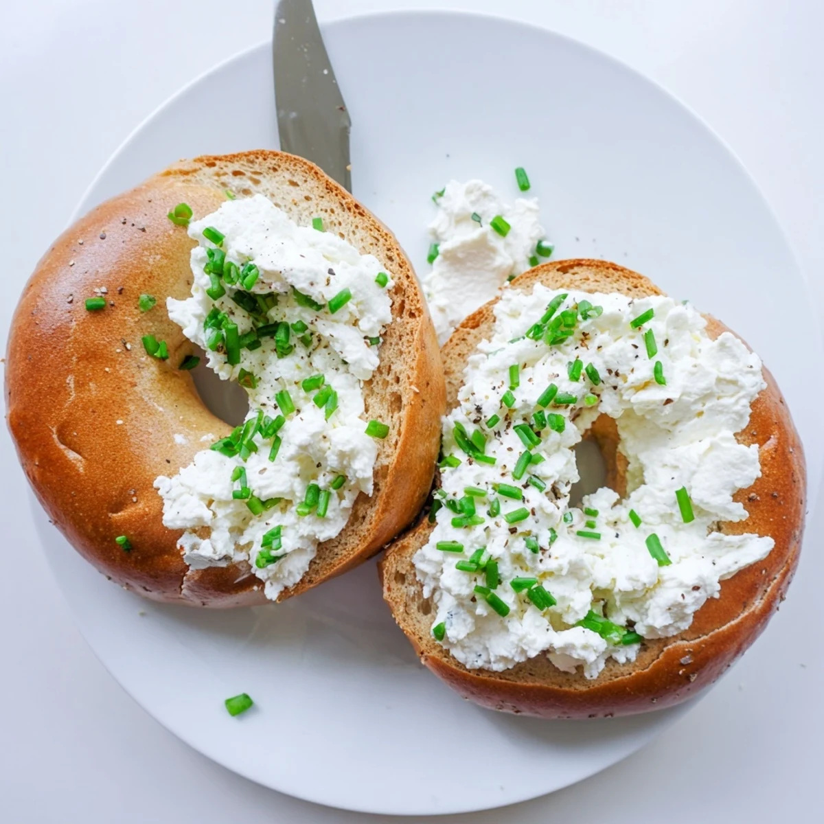 Protein Bagels with Cottage Cheese sit beside smoked salmon on a rustic wooden serving board.