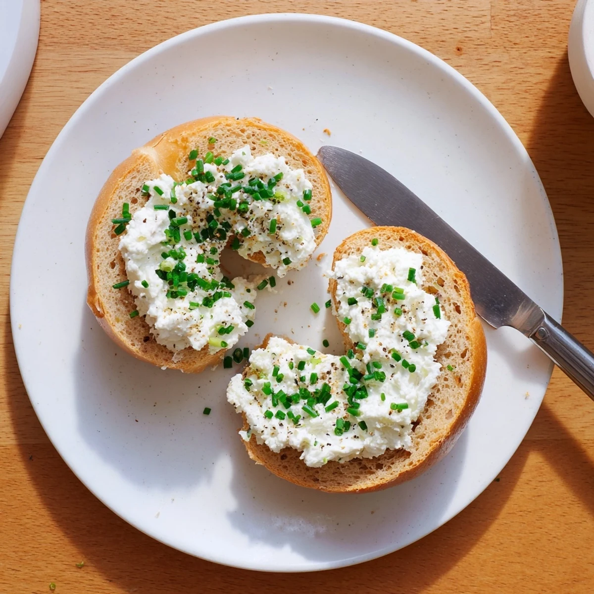 Freshly baked Protein Bagels with Cottage Cheese have a golden crust and are topped with chives.