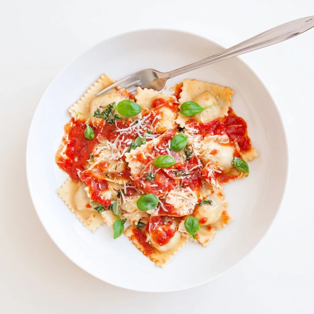 Freshly boiled ravioli coated in aromatic tomato sauce, topped with grated Parmesan and basil.