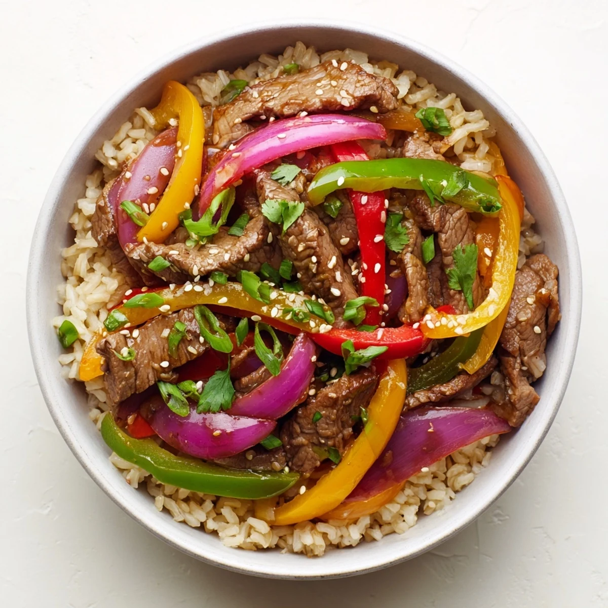 Healthy Beef and Pepper Rice Bowl served in a ceramic bowl with garnishes, perfect for a quick weeknight meal.