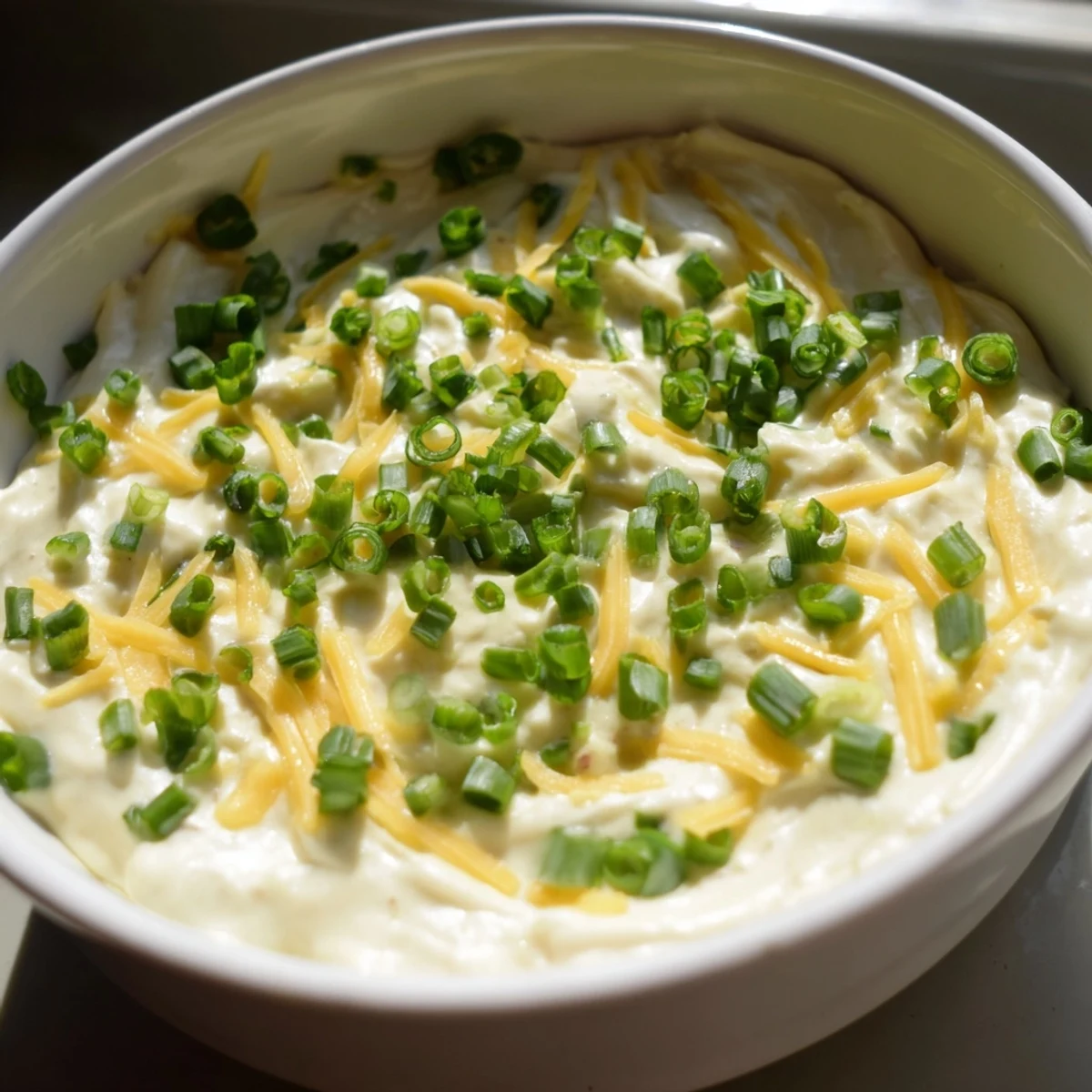 Golden savory pretzel dip topped with green onions perfect for party appetizer dipping
