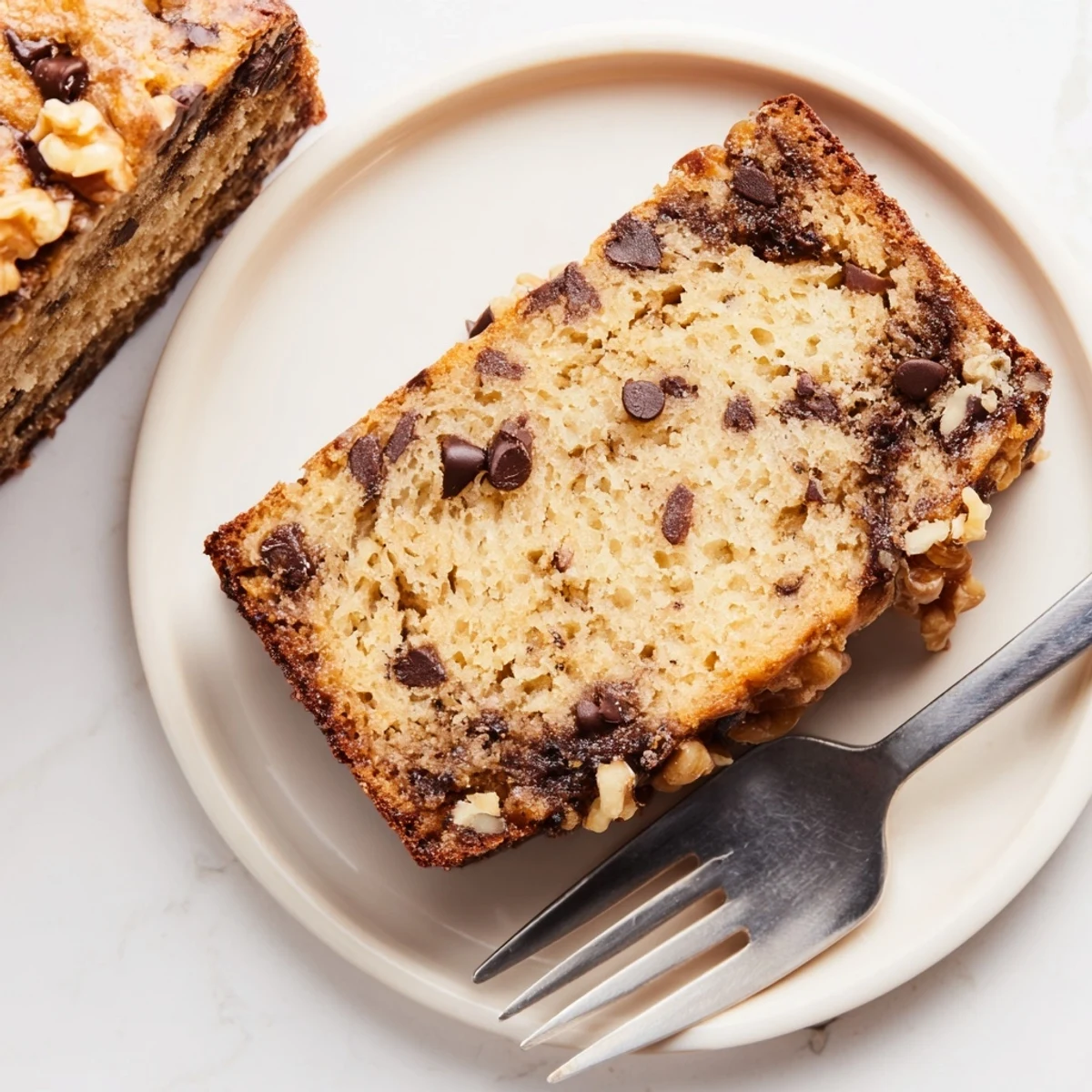 Slice of chocolate chip banana bread showing moist crumb texture and scattered chocolate morsels