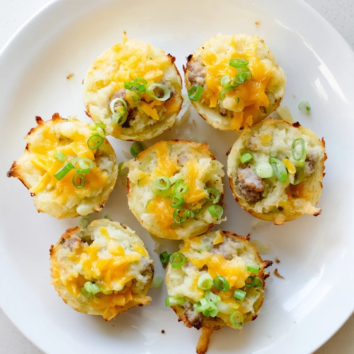 Bite-sized St. Patricks Irish sausage and mashed potato cups garnished with fresh scallions