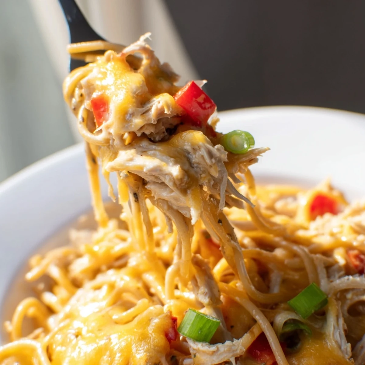 Comforting Monterey Chicken Spaghetti dish with melted cheese topping, diced peppers, and perfectly cooked spaghetti strands
