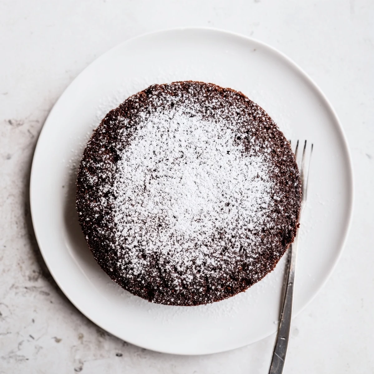 Rich dark chocolate Guinness cake slice revealing tender crumb with white powdered sugar