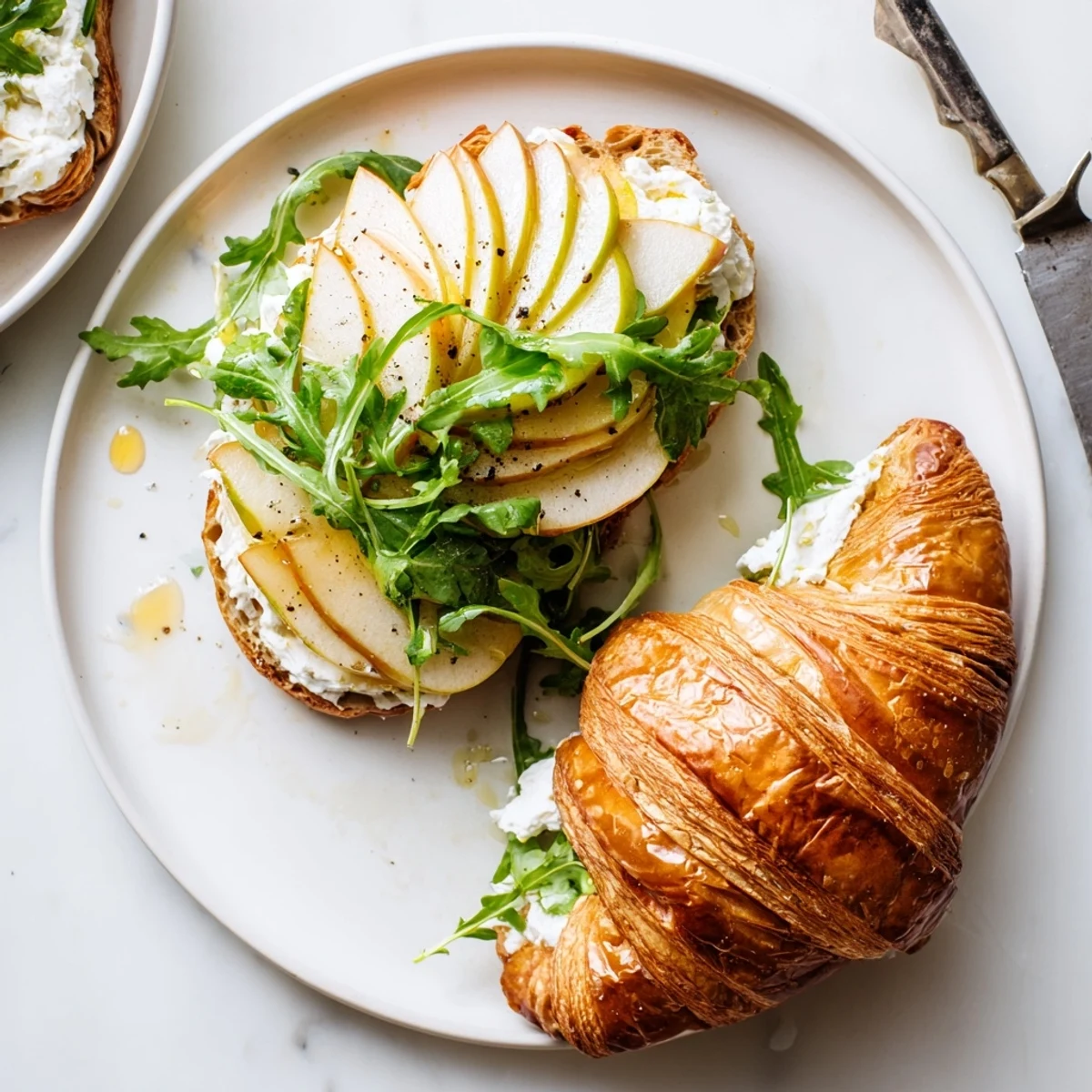 Golden flaky croissant sandwich stuffed with creamy goat cheese and crisp green apple slices