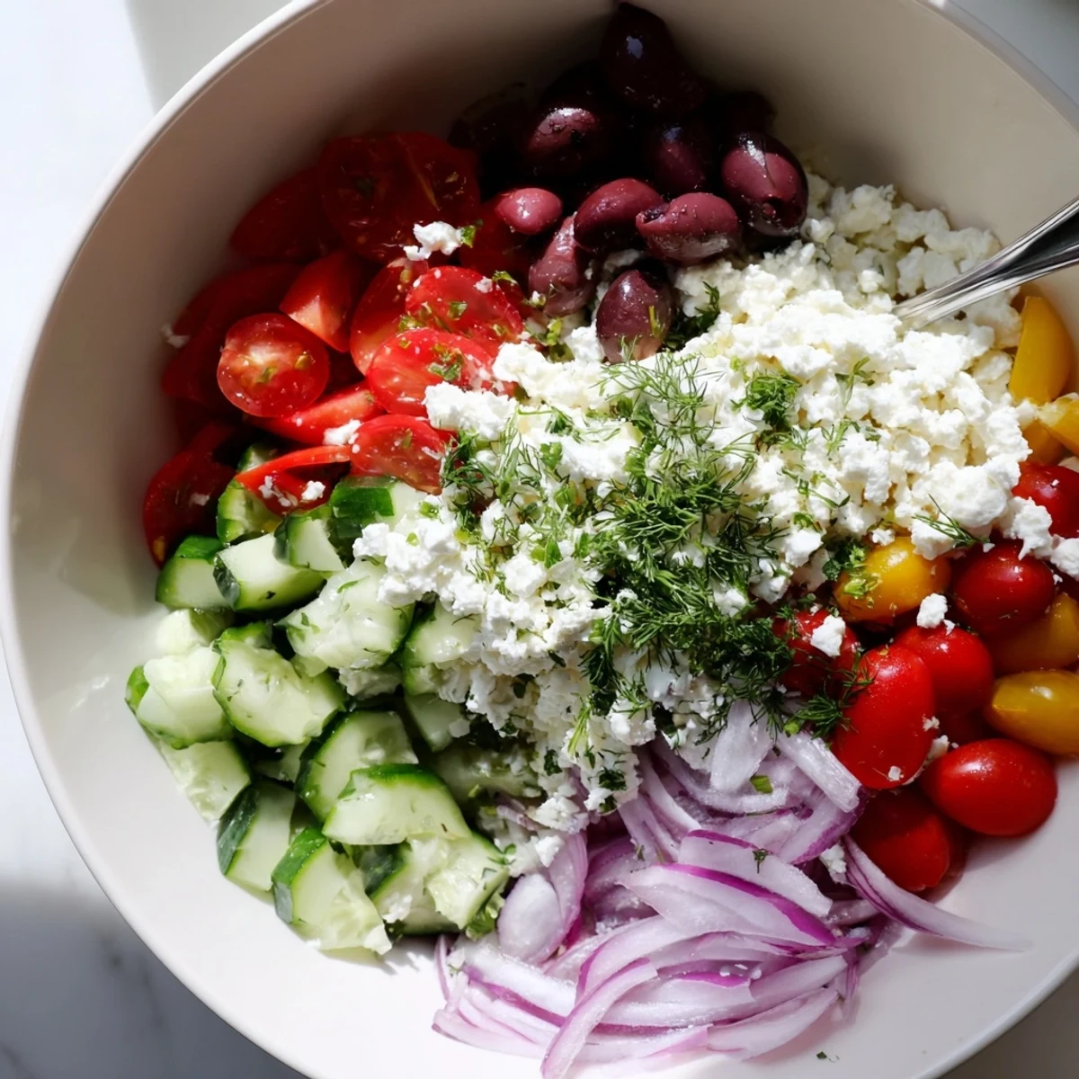 Fresh Greek salad cottage cheese bowl topped with colorful vegetables and crumbled feta in white serving dish