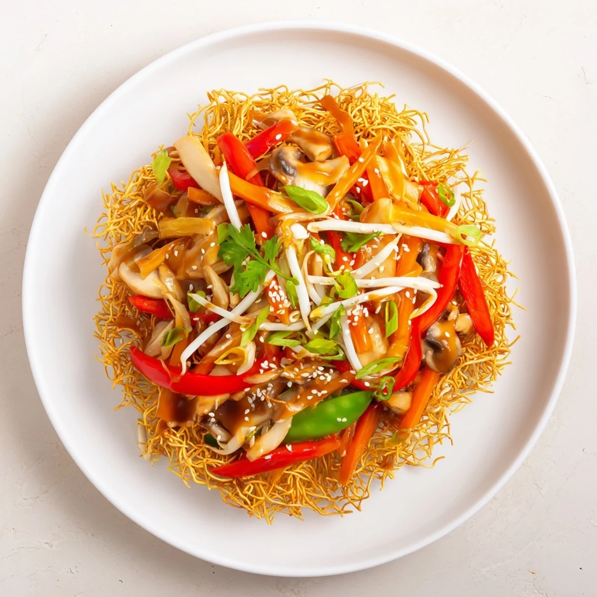 Vibrant vegetable medley tossed with crispy fried noodles on a white serving platter