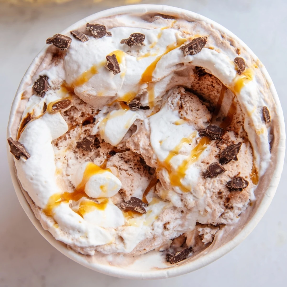 Dark chocolate Ninja Creami Phish Food ice cream topped with mini chocolate fish and sticky caramel