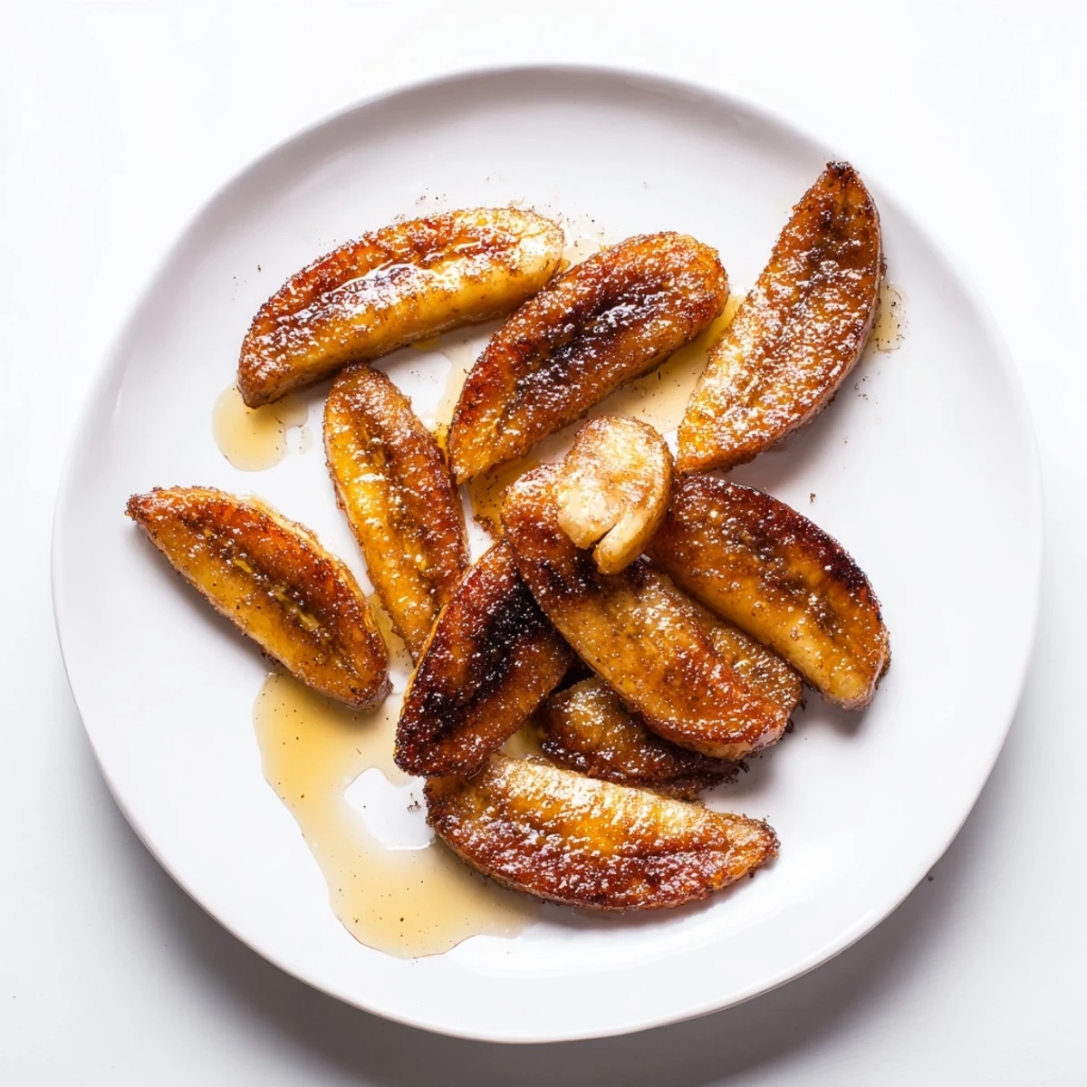 Sweet diagonal slices of pan fried cinnamon bananas on white plate