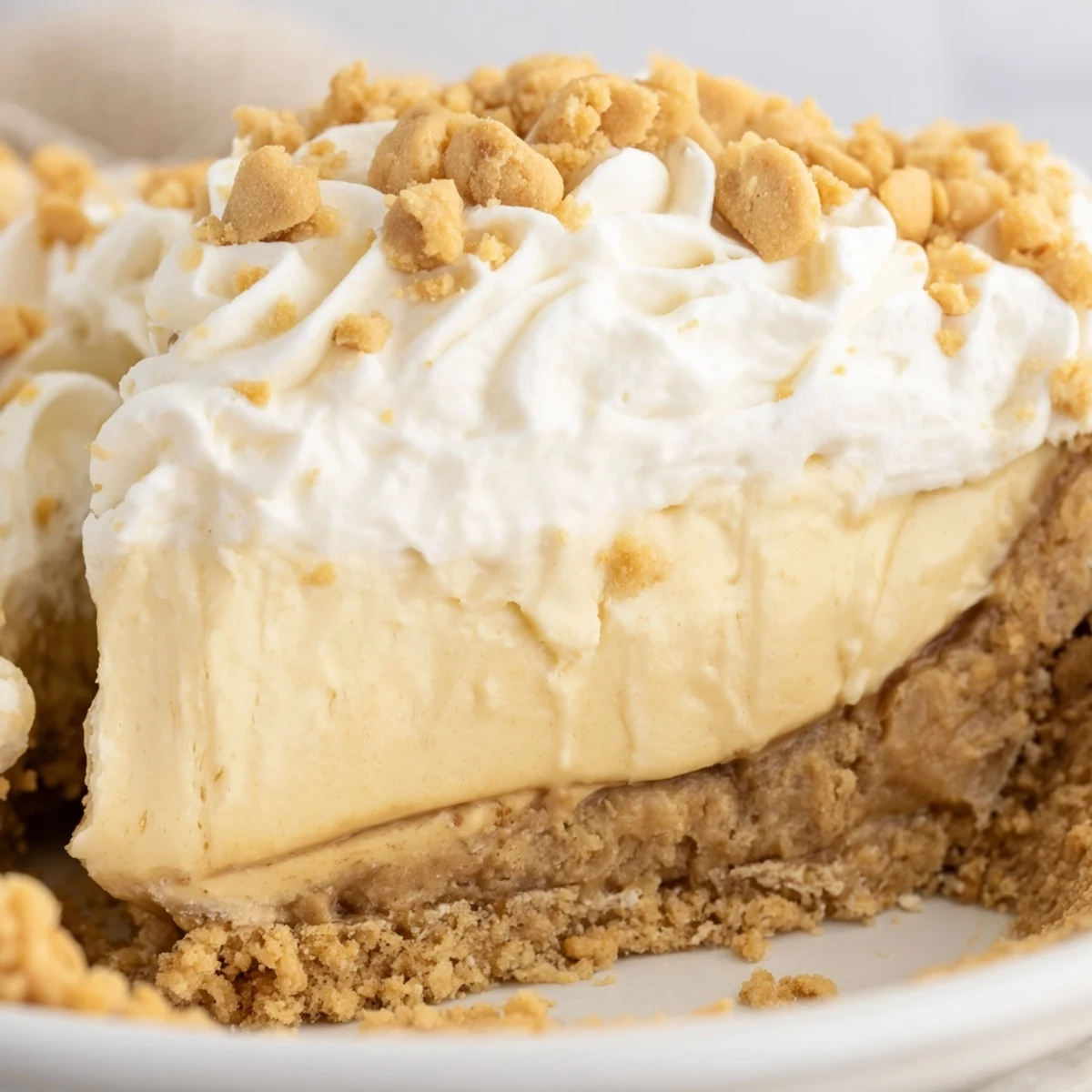 Creamy Old Fashioned Amish Peanut Butter Dream Pie topped with whipped cream and golden crumbs