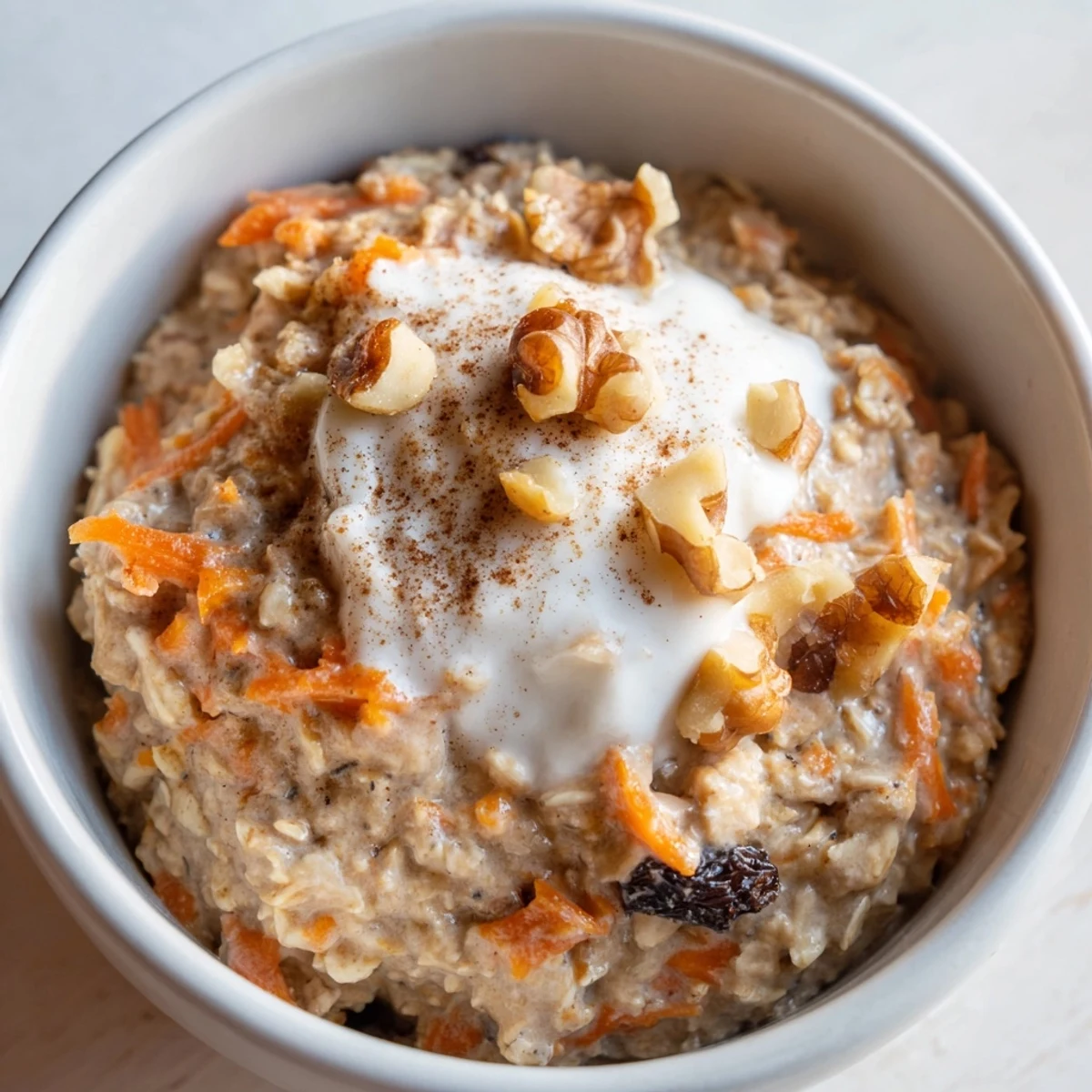 Creamy carrot cake overnight oats in a mason jar topped with chopped walnuts and cinnamon