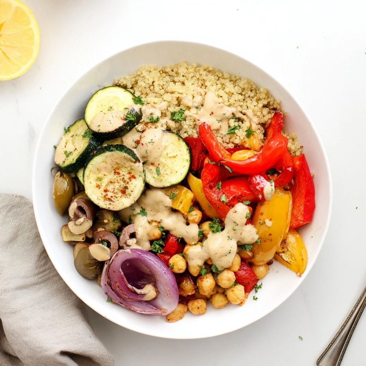 Golden roasted eggplant and peppers in a vegan Mediterranean roasted vegetables bowl drizzled with creamy tahini.