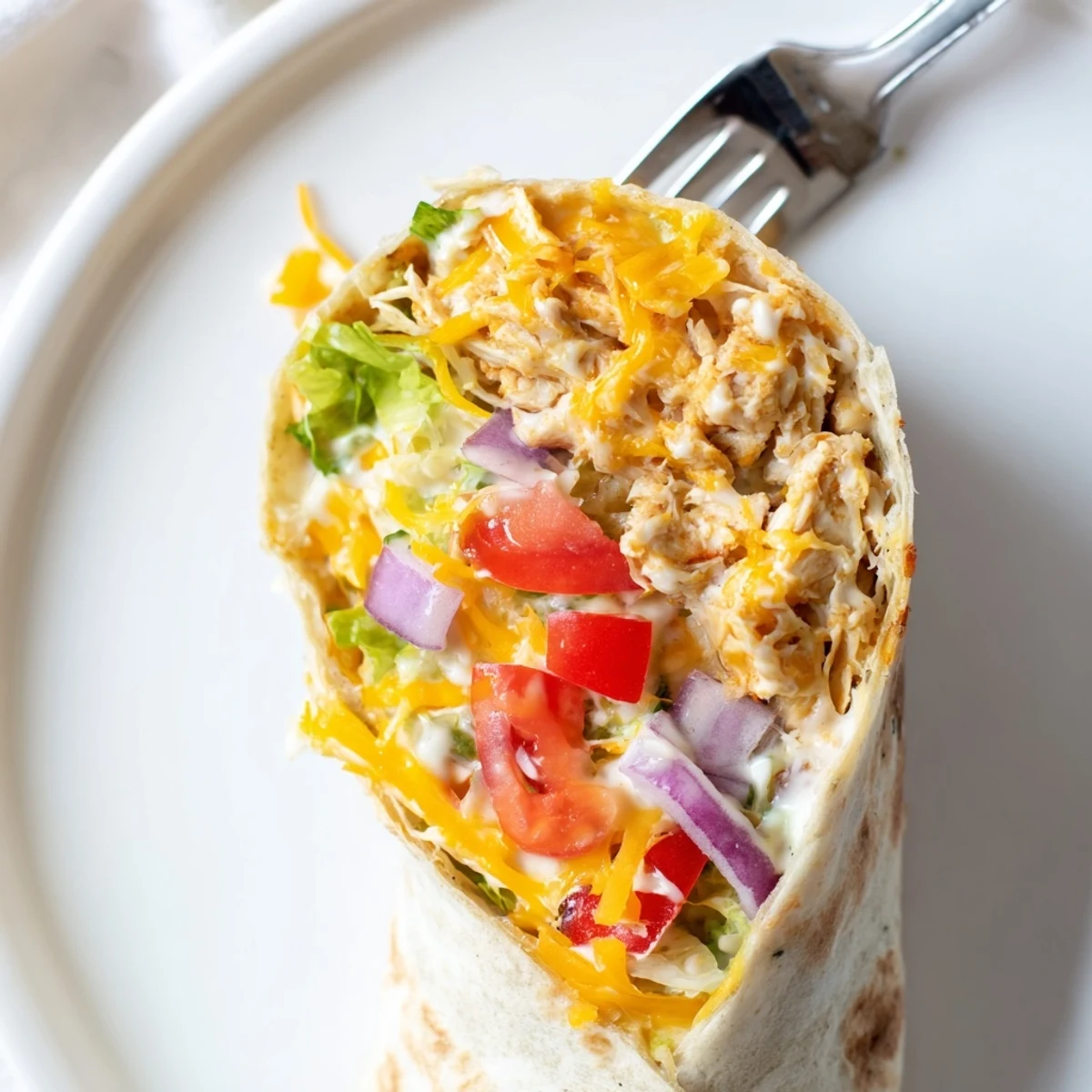 Cheesy Garlic Chicken Wraps with melted cheddar, warm tortillas and crisp lettuce.