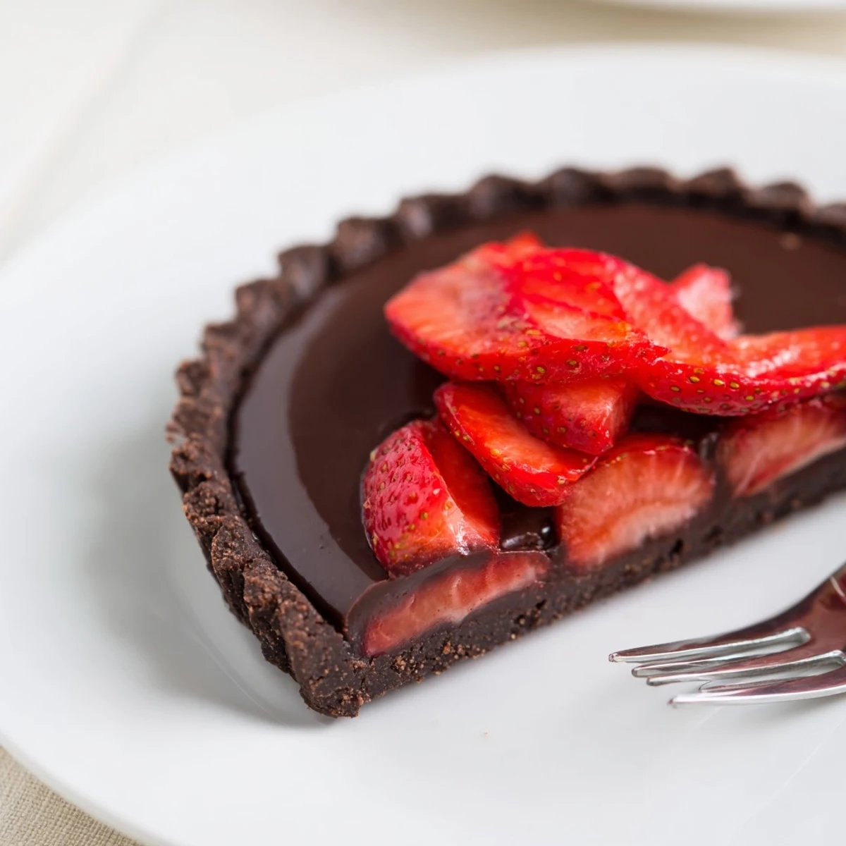 Glazed strawberries crown a chilled Dark Chocolate Strawberry Tart Recipe for dessert