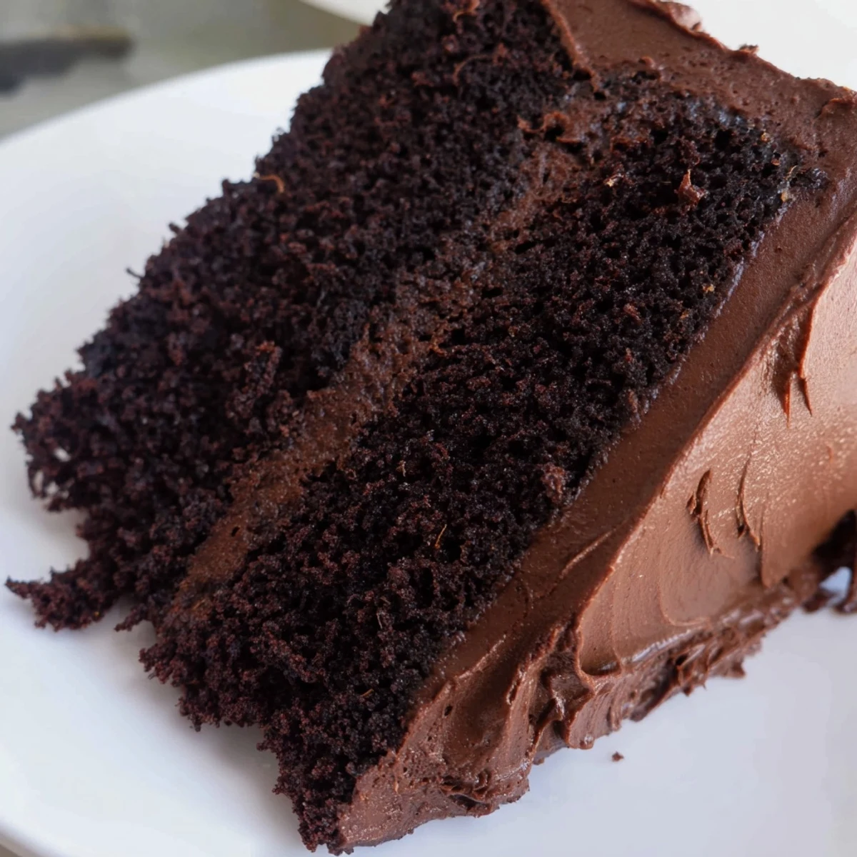 Decadent Matildas chocolate cake layered with rich creamy frosting and topped with chocolate shavings
