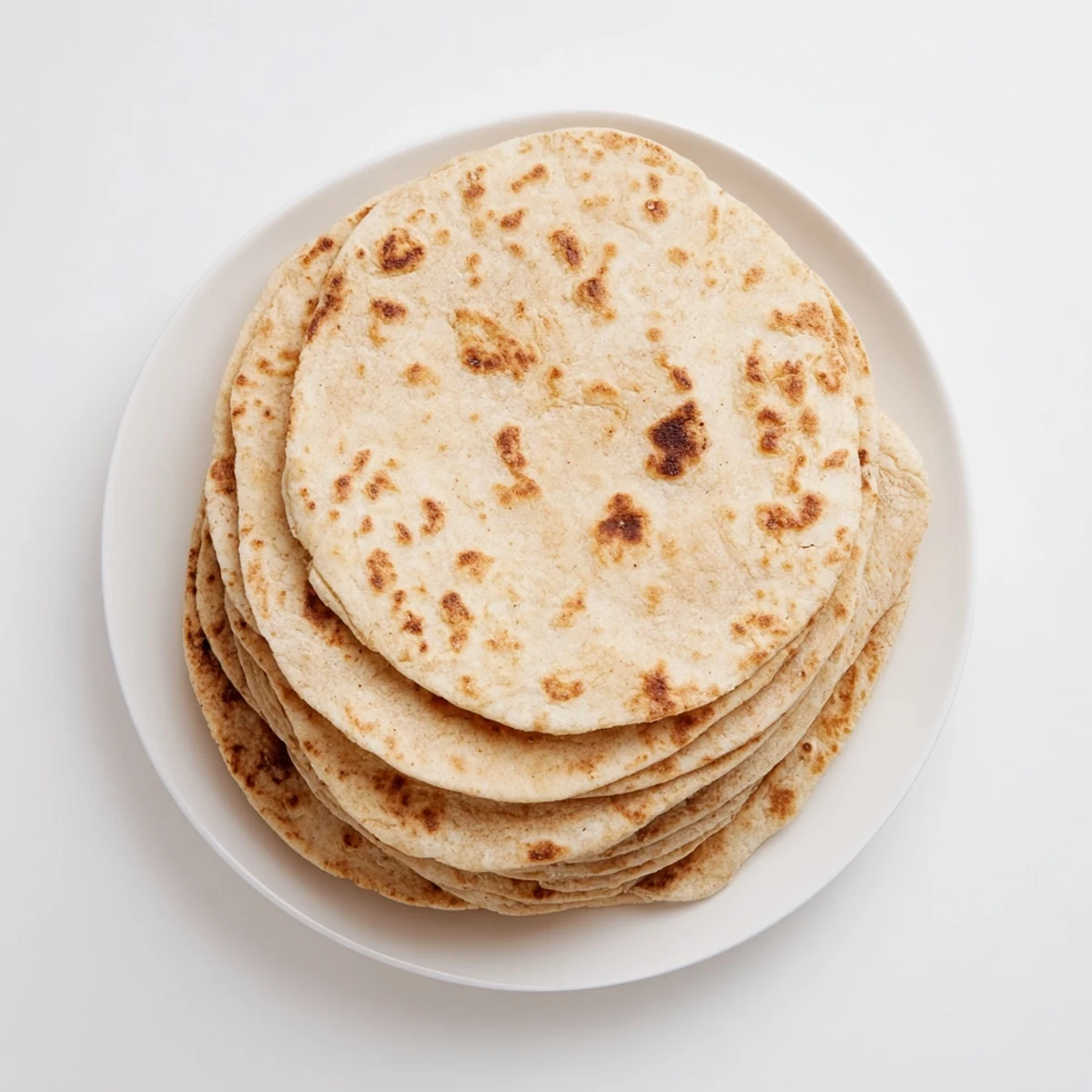 Warm soft sweet potato cassava tortillas being folded to reveal their pliable texture on a plate