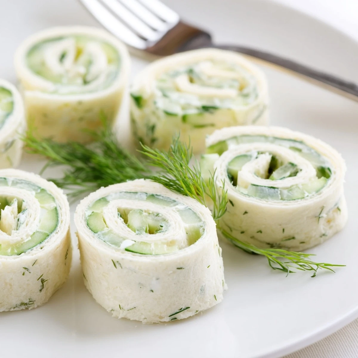 Cucumber And Dill Pinwheels arranged on platter, chilled, creamy cucumber bites  