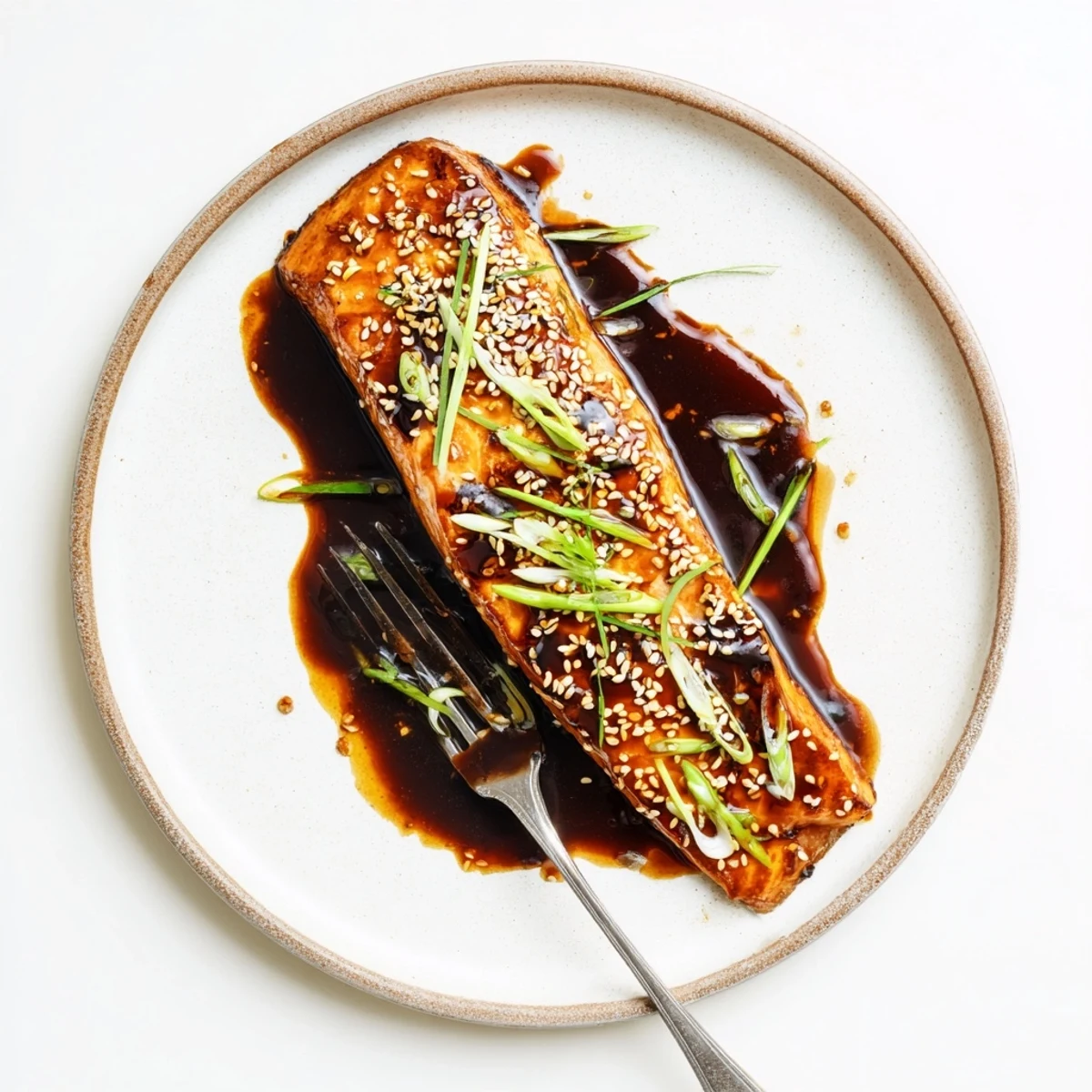 Tender gluten free teriyaki salmon garnished with spring onions and steamed rice
